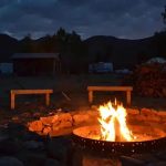 Families gathered around a campfire at Stagecoach Trails Campground during an evening outdoor gathering